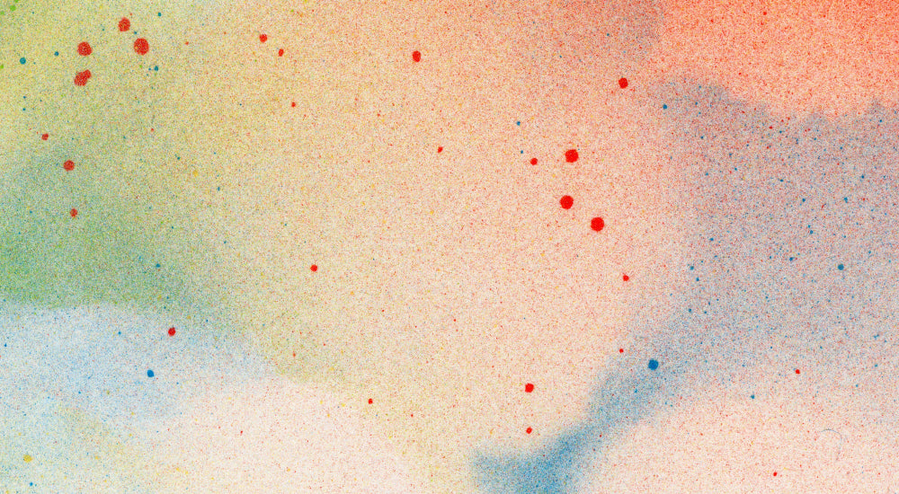 Colorful abstract pattern with scattered red dots on a textured background