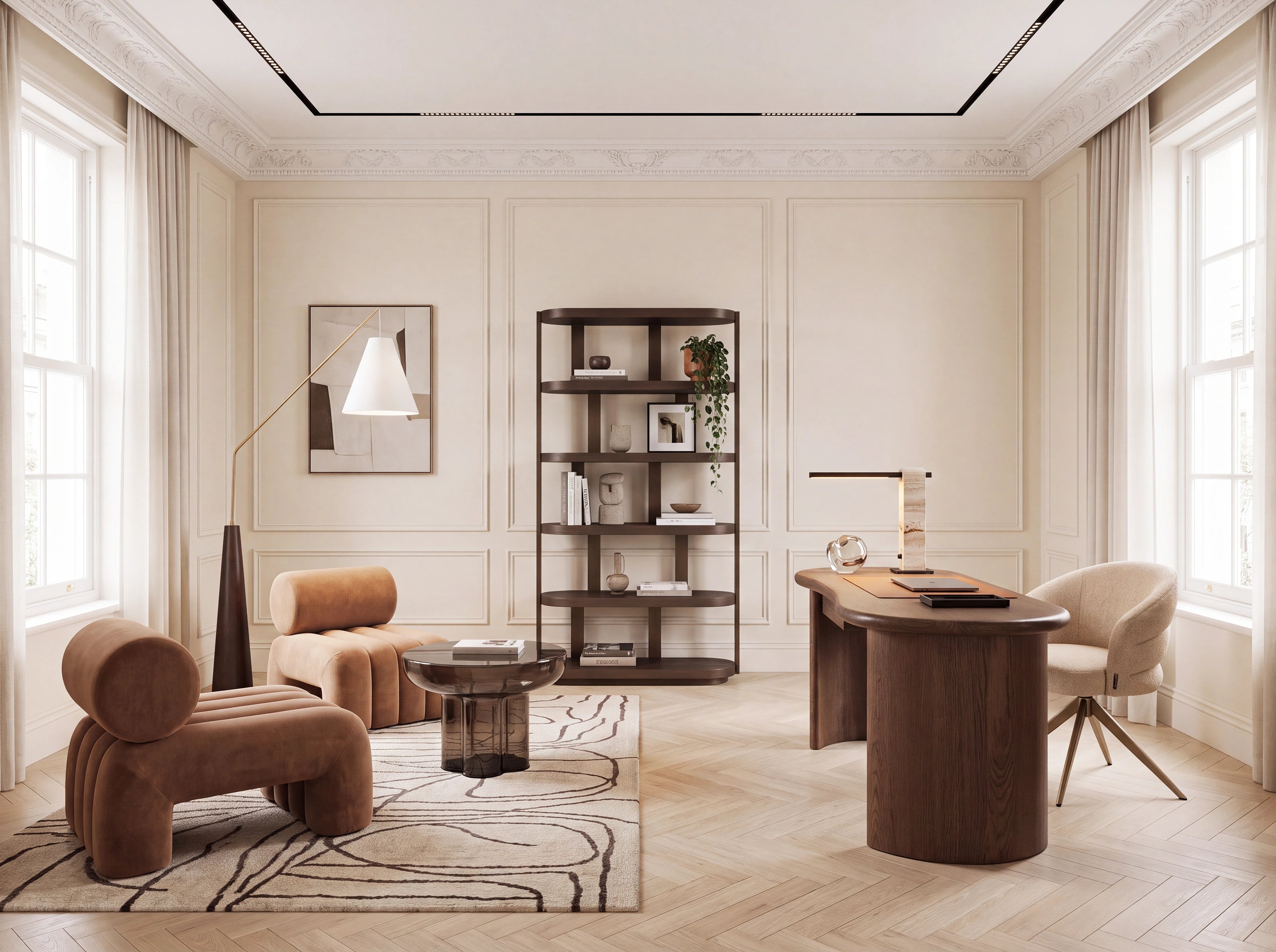 A styled interior room with cream walls, herringbone wood flooring, a large sculptural brown lounge chair, a matching armchair, a round coffee table, a tall shelving unit, and a wooden desk with a chair by tall windows.