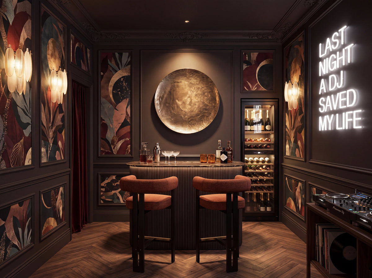 A luxurious dark-themed DJ booth or home bar interior with two orange-brown barstools in front of a ribbed bar counter, a wine refrigerator, and decorative wall art. A glowing neon sign on the right reads 'LAST NIGHT A DJ SAVED MY LIFE'.